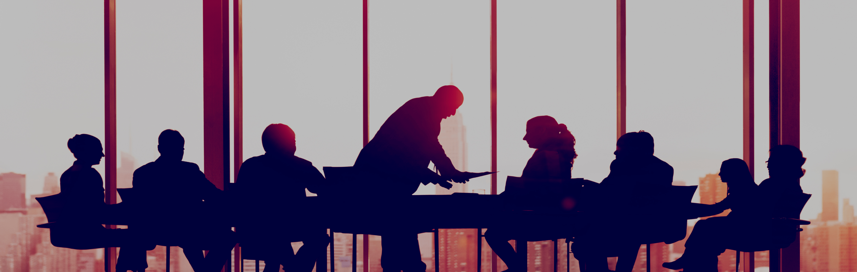 Silhouette of a corporate management team in a meeting, with a focus on leadership and decision-making.