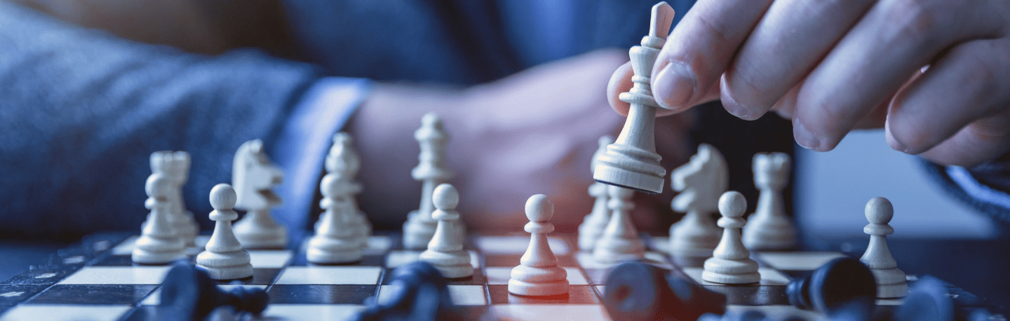 Close-up of hands moving a chess piece on a board, symbolizing strategic leadership and decision-making