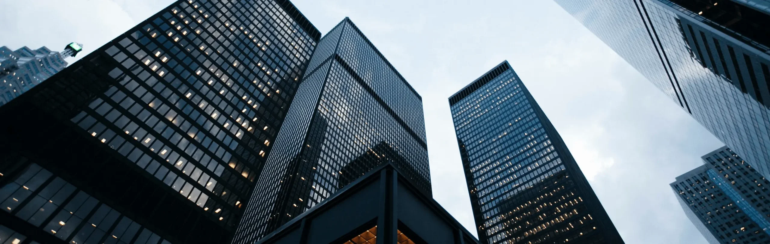 Modern city skyline with tall glass buildings, representing a unified force shaping the infrastructure landscape. 7 rings cement