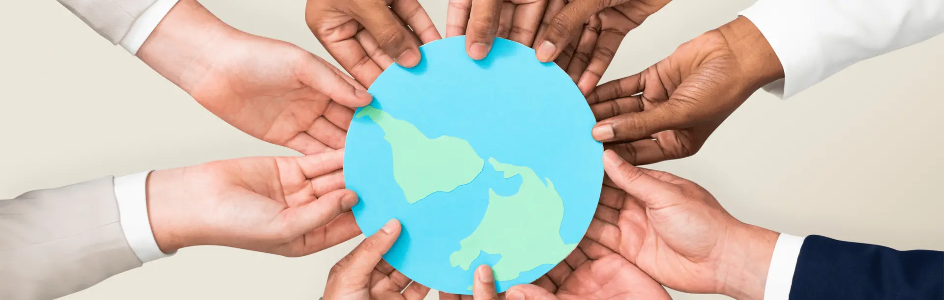 Diverse hands holding paper cutout of the Earth for community empowerment